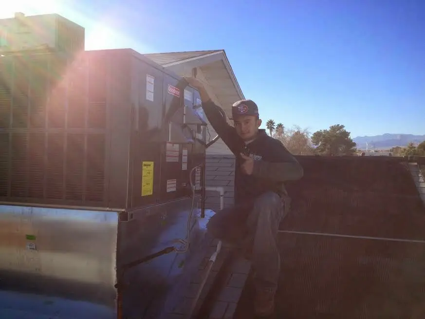 HVAC technician performing HVAC Inspection on a rooftop unit in Welcome